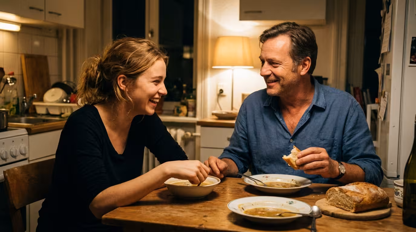 A couple delighted with each other over a simple homemade dinner at an ordinary kitchen table