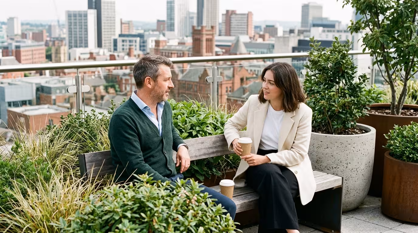 Man and young woman with coffee on a rooftop garden terrace above Birmingham city centre